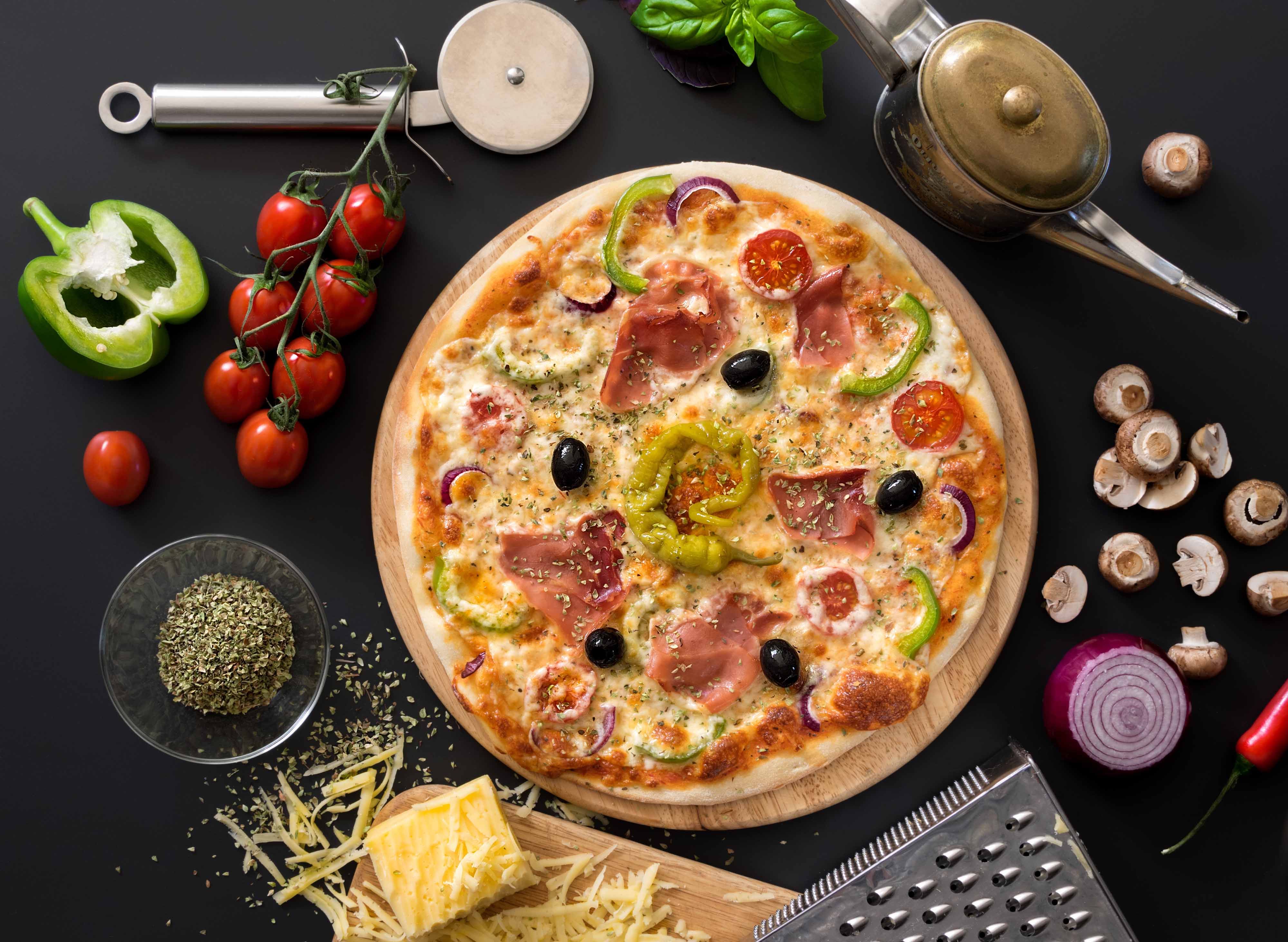 Vedugnsbakad pizza på Basilico Uppsala — prosciutto, oliver, paprika